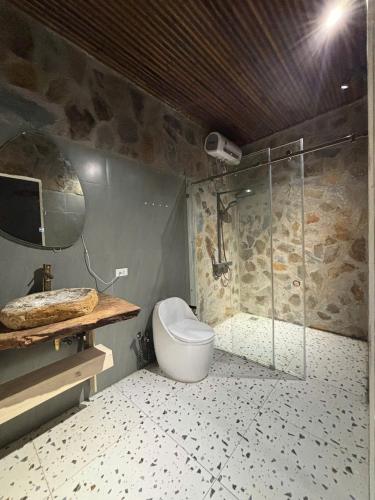 a bathroom with a toilet and a glass shower at Chậm Viên Le Jardin in Thanh Lâm