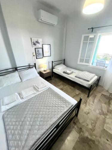 a bedroom with two beds and a window at Τequila Sunrise in Áyios Pétros