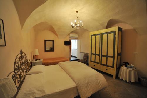 a bedroom with a large bed and a chandelier at Erasmo Rooms & Breakfast in Finale Ligure