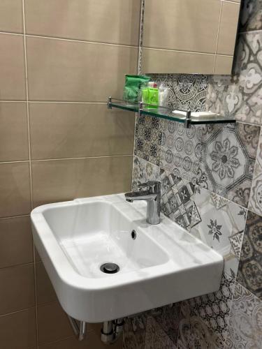 a white sink in a bathroom with a mirror at Matera Central Nest in Matera