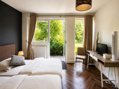 a bedroom with two beds and a desk with a computer at La Belle Heure B&B - formerly Huis van Steen - in Lelystad