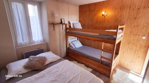 a bedroom with two bunk beds and a window at Cozy high-altitude apartment in Font-Romeu-Odeillo-Via