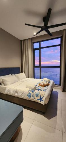 a bedroom with a bed and a ceiling fan at 4BR Beachfront Pantai Cenang Langkawi in Pantai Cenang