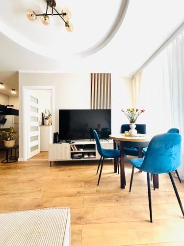 a living room with a table and blue chairs at Sowia Przystań in Nowa Ruda