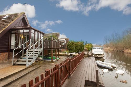 ein Haus auf einem Dock neben einem Fluss in der Unterkunft Isleham River Lodge in Isleham