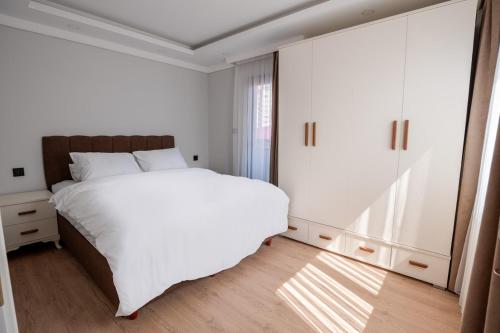 a bedroom with a large white bed and a window at Royal Batın Apart Otel in Trabzon