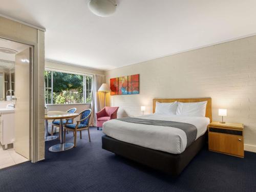 ein Hotelzimmer mit einem Bett und einem Tisch in der Unterkunft ibis Styles Canberra in Canberra