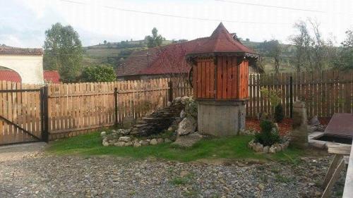 a garden with a wooden fence and a wooden structure at Pensiunea agroturistica "Cheile Cibului" in Cib