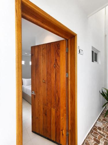 a wooden door in a room with a bed at Hotel Isla Mujeres Centro & Beach Club Included in Isla Mujeres