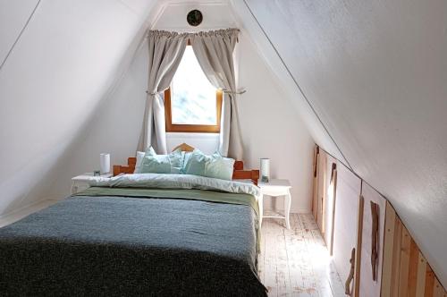 a bedroom with a large bed with a window at MOHA guesthouse in Szokolya