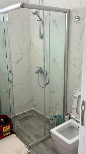a bathroom with a shower with a toilet and a sink at Caesar Blue Studio Sea View Apartment in Boghaz