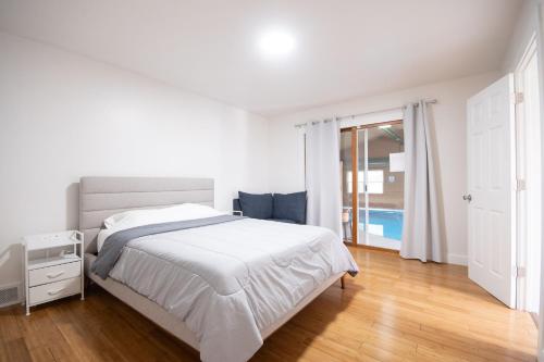 a white bedroom with a bed and a pool at Private Heated Pool House with Sauna CL in Crystal Lake