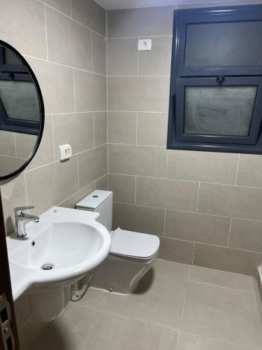 a bathroom with a toilet and a sink and a mirror at جايا راس الحكمه in Jalāl