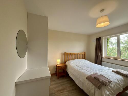 a bedroom with a bed and a window at An Tulan Cleasach Spiddal in Spiddal
