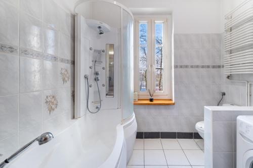 a white bathroom with a tub and a sink at Dwupoziomowy apartament in Dęblin
