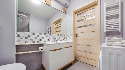 a bathroom with a sink and a toilet and a mirror at Jantar Park in Jantar