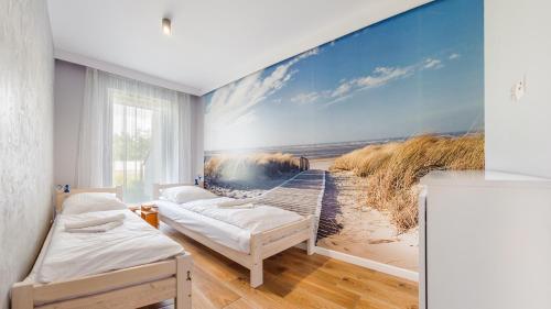 a room with two beds and a beach wall mural at Jantar Park in Jantar