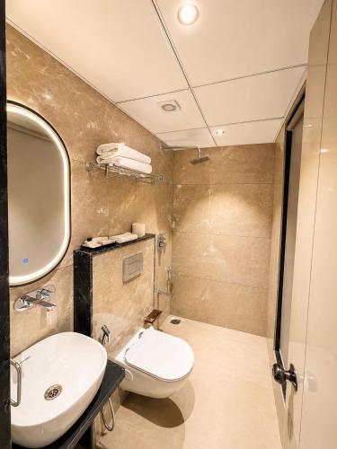 a bathroom with a white toilet and a sink at Fun Hotels Gandhinagar in Gandhinagar