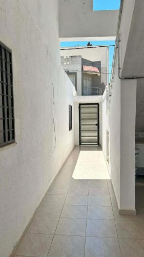 ein Flur eines weißen Gebäudes mit einer Garage in der Unterkunft Marsa plage kelibia in Kelibia