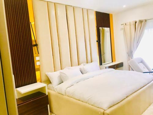 a bedroom with a white bed and a window at NewAge Smart 2 in Ikeja