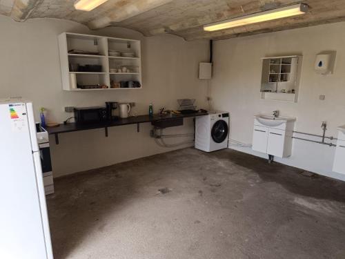 a laundry room with a washer and a washing machine at Frifelt Kro Almost Glamping telt in Frifelt