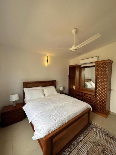 a bedroom with a large bed and a mirror at Coastal Escape Haven in Mchamba Wima