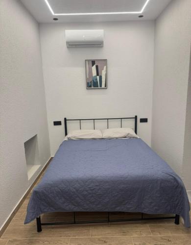 a bedroom with a bed with a blue blanket at Downtown ViAlla Studio in Chios