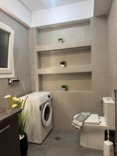 a bathroom with a washing machine and a washer at Downtown ViAlla Studio in Chios