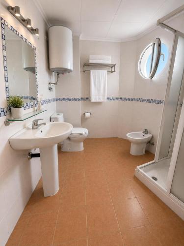 a bathroom with a sink and a toilet and a mirror at Urban Suite in Los Alcázares
