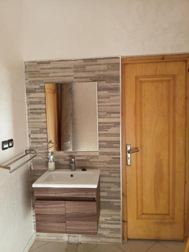 a bathroom with a sink and a wooden door at house dream in Berkane