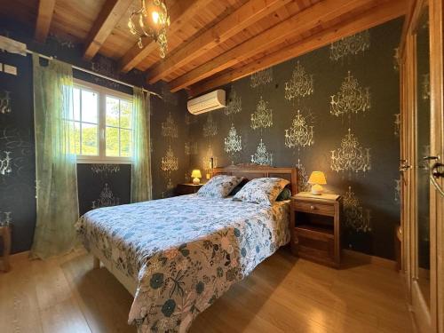 a bedroom with a bed with a blue comforter at Ticoulat in Monein