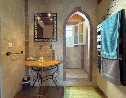 a bathroom with a shower with a table and a sink at Ticoulat in Monein