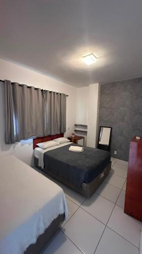 a hotel room with two beds and a window at Beleleus Jeri in Jericoacoara