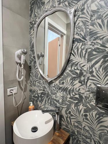 a bathroom with a mirror and a sink at DS Apartment in Catania