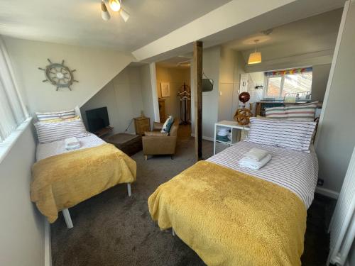 a bedroom with two beds and a living room at Hope Corner in Filey