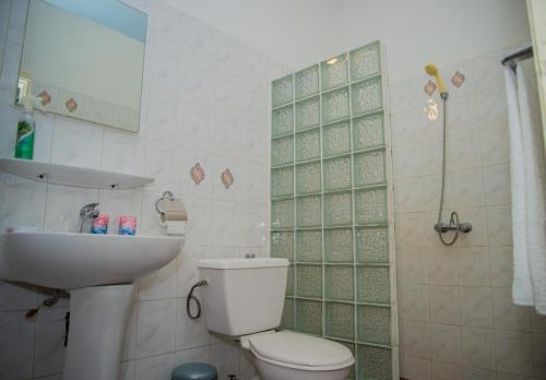 a bathroom with a toilet and a sink and a shower at Résidence Touraco in Abidjan
