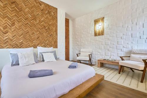 a bedroom with a large white bed and a chair at L'étoile d'Arras in Arras