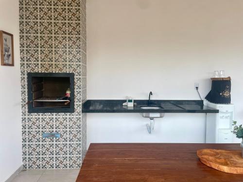 a kitchen with a sink and a fireplace at Jacuzzi Privativa, Chalé Romântico com Decoração in Monte das Gameleiras