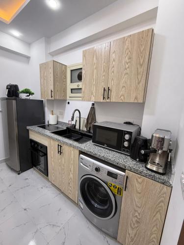 a kitchen with a washer and a sink and a dishwasher at Résidence privée à hurgada avec piscine in Hurghada