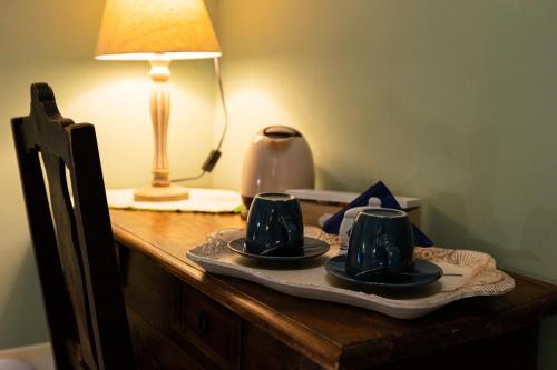 a table with three tea cups and a lamp on it at Palazzo Diamante in Calascio