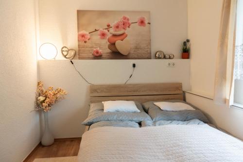 ein Schlafzimmer mit zwei Betten und einem Gemälde an der Wand in der Unterkunft Ferienhaus WaldPeter bei CaroGrün in Erfurt-gemütlich-sonnig-Garten-Parken-Pool-Sauna-WLAN in Erfurt