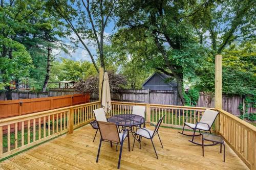 a patio with a table and chairs on a wooden deck at Rustic Retreat in Franklin