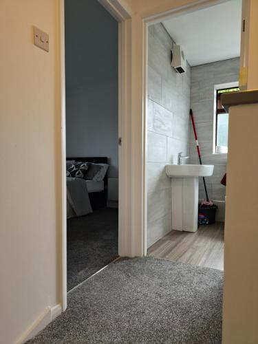 a bathroom with a sink and a room with a bed at Chilux in Rainham