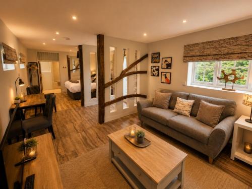 a living room with a couch and a table at The Stalls Suite at Strattons in Swaffham