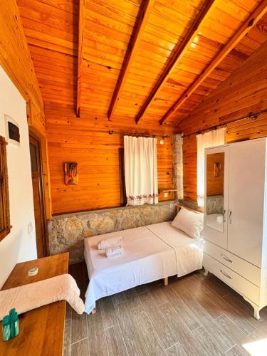 a bedroom with a bed in a wooden room at Petrinos Butik Otel in Datca