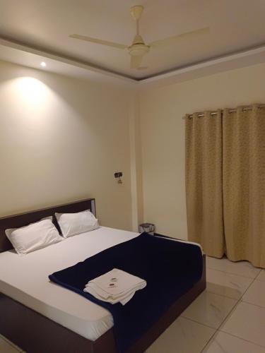 a bedroom with a bed with a towel on it at Hotel Bhagwati Palace in Ujjain