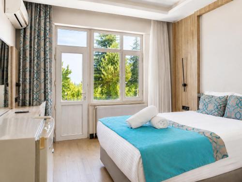 a hotel room with a bed and a window at Elazığ Mavigöl Otel in Sivrice