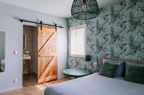 a bedroom with a bed and a door and a window at Casa Cava B&B in Dendermonde
