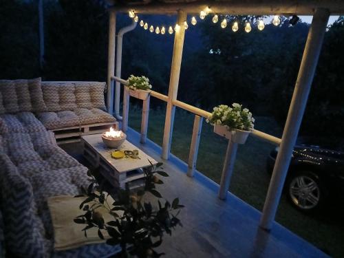 una veranda con un divano, un tavolo e delle luci di Vila Obradovic ad Arilje