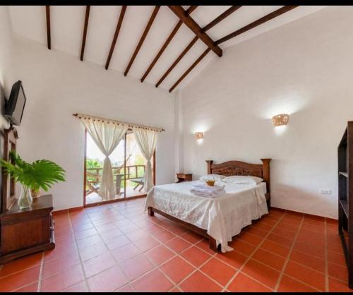a bedroom with a bed and a large window at Casa de Teja Barichara in Barichara